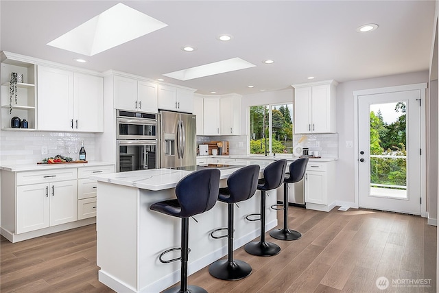 900 Sea Vista Pl, Edmonds, WA 98020 - kitchen with a skylight, appliances with stainless steel finishes, open shelves, light wood-style floors, and recessed lighting