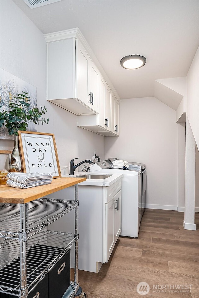 900 Sea Vista Pl, Edmonds, WA 98020 - washroom featuring washer and clothes dryer, light wood-style floors, baseboards, and cabinet space