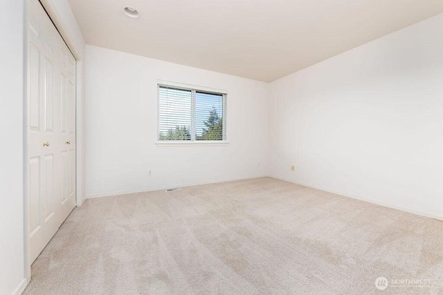 unfurnished bedroom with carpet flooring, baseboards, and a closet
