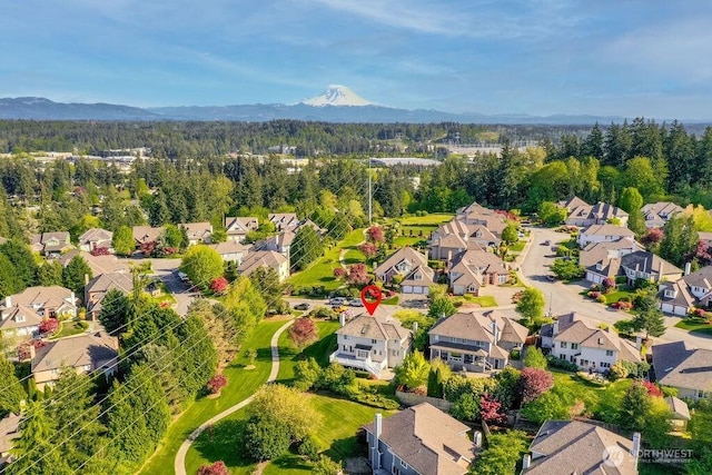aerial perspective of suburban area featuring mountains and a heavily wooded area