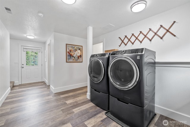 13520 Burn Rd, Arlington, WA 98223 - washroom with washing machine and clothes dryer, baseboards, and wood finished floors