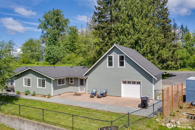 13520 Burn Rd, Arlington, WA 98223 - view of front of house featuring a garage, a fenced backyard, asphalt driveway, and a patio area