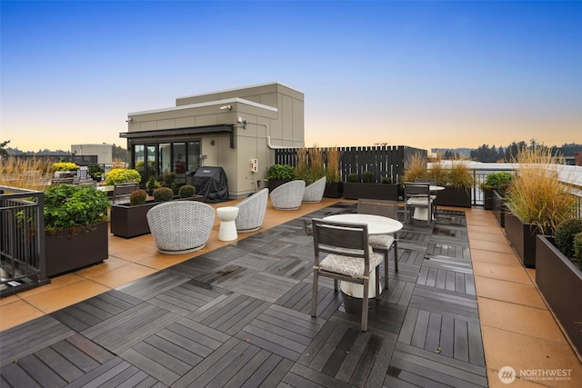 11903 NE 128th St Unit 612, Kirkland, WA 98034 - patio terrace at dusk with outdoor dining area, grilling area, and a wooden deck