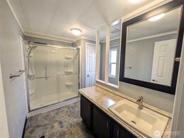 201 Union Ave SE Unit 136, Renton, WA 98059 - bathroom featuring a stall shower, vanity, ornamental molding, a textured ceiling, and stone finish floors