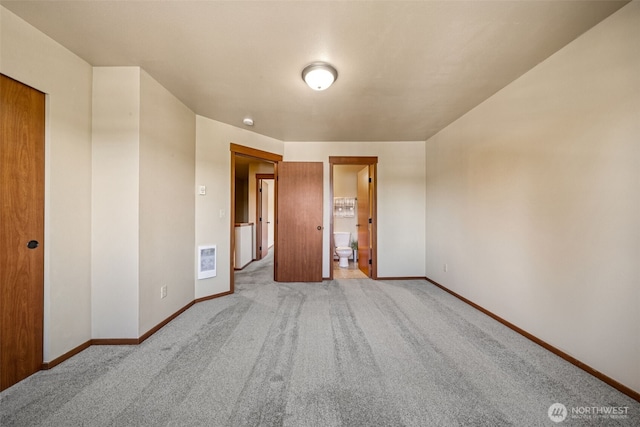 unfurnished bedroom with carpet floors, baseboards, and connected bathroom