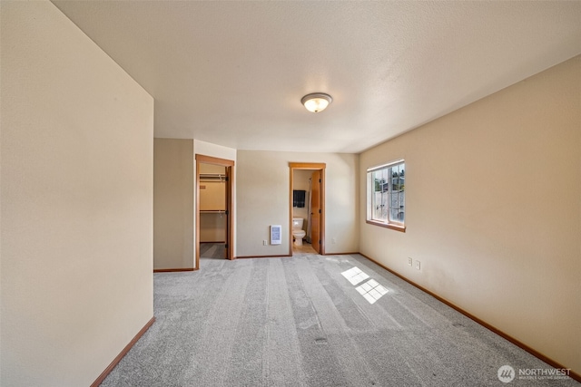 carpeted empty room with baseboards