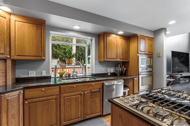 7819 Tolt River Rd NE, Carnation, WA 98014 - kitchen with a sink, stainless steel appliances, brown cabinets, recessed lighting, and dark stone countertops