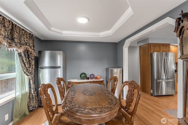 7819 Tolt River Rd NE, Carnation, WA 98014 - dining space featuring a raised ceiling, light wood-style floors, and ornamental molding