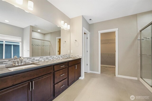 17702 SE 265th Ct, Covington, WA 98042 - full bath with a stall shower, a walk in closet, double vanity, tile patterned floors, and backsplash