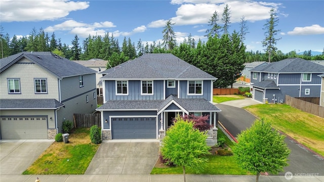 17702 SE 265th Ct, Covington, WA 98042 - view of front of home with board and batten siding, an attached garage, concrete driveway, stone siding, and a shingled roof