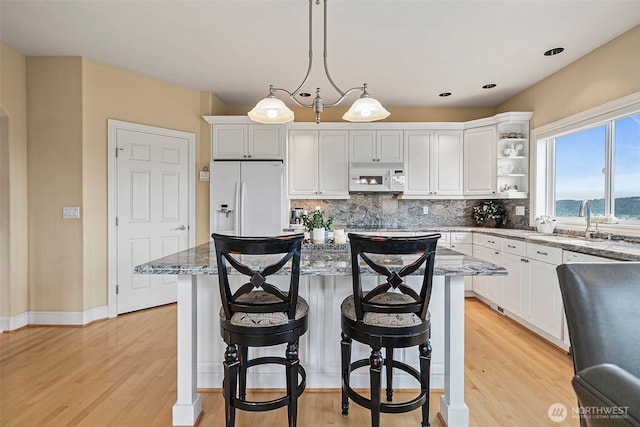 4316 Crystal Lane Loop SE, Puyallup, WA 98372 - kitchen with white appliances, light wood finished floors, tasteful backsplash, light stone countertops, and recessed lighting