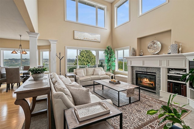 4316 Crystal Lane Loop SE, Puyallup, WA 98372 - living room with a high end fireplace, a towering ceiling, plenty of natural light, and light wood-style flooring