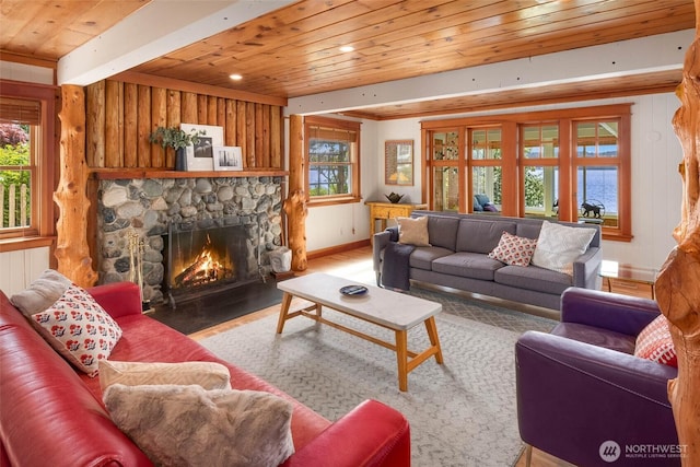 14010 SW Bates Rd, Vashon, WA 98070 - living room with a stone fireplace, wooden ceiling, healthy amount of natural light, wood finished floors, and baseboards