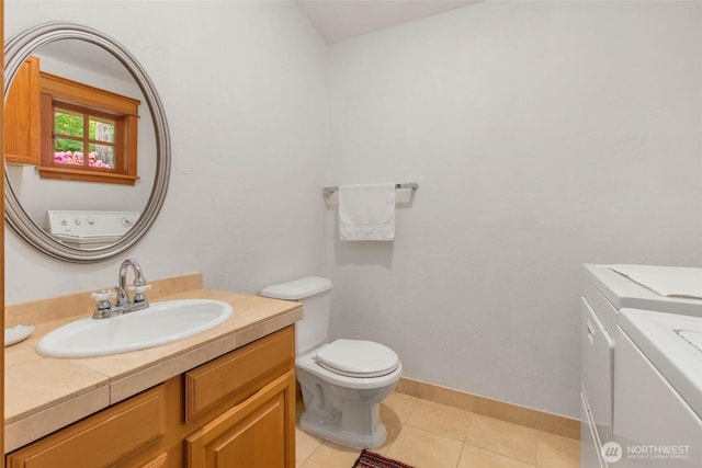14010 SW Bates Rd, Vashon, WA 98070 - bathroom featuring washer and dryer, toilet, vanity, tile patterned flooring, and baseboards