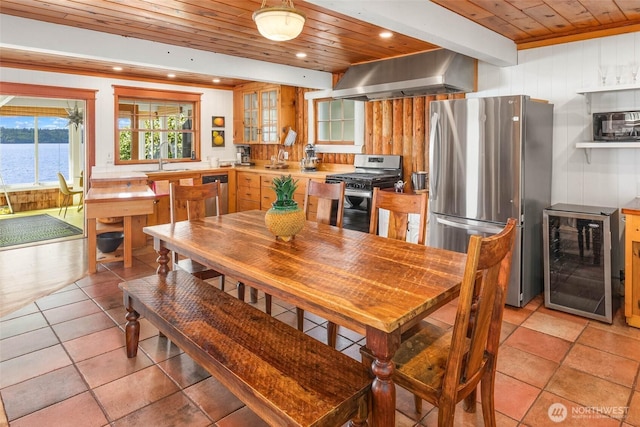 14010 SW Bates Rd, Vashon, WA 98070 - dining space with wine cooler, wood ceiling, recessed lighting, light tile patterned floors, and wooden walls