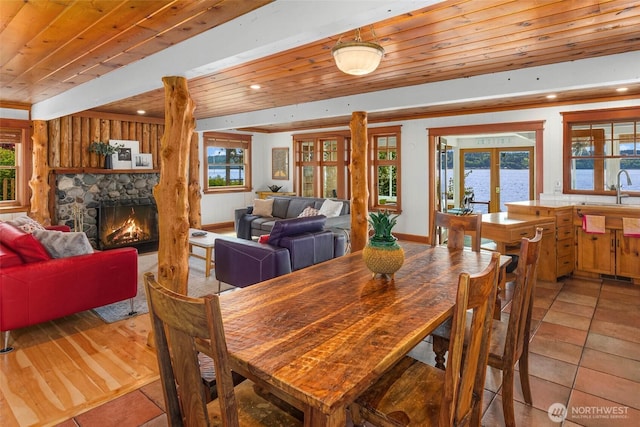 14010 SW Bates Rd, Vashon, WA 98070 - dining room featuring french doors, wood ceiling, light tile patterned flooring, and a fireplace