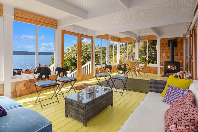 14010 SW Bates Rd, Vashon, WA 98070 - sunroom with a wood stove, beamed ceiling, a deck with water view, hardwood / wood-style flooring, and wood walls