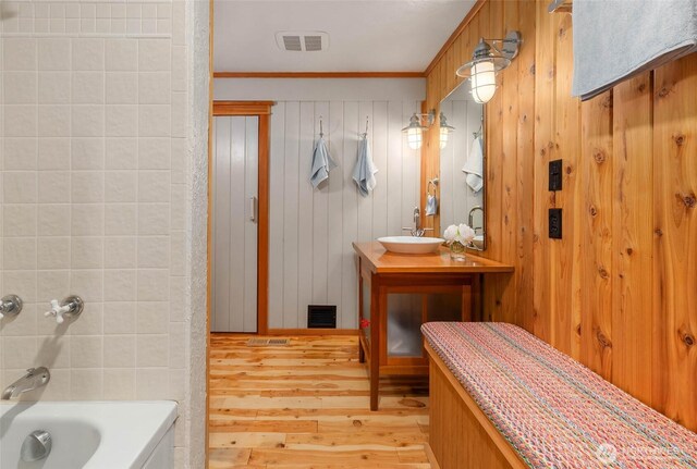 14010 SW Bates Rd, Vashon, WA 98070 - full bathroom with wood finished floors, vanity, ornamental molding, shower / bath combination, and wooden walls