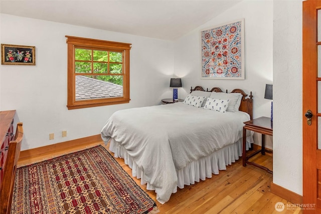 14010 SW Bates Rd, Vashon, WA 98070 - bedroom featuring wood-type flooring, vaulted ceiling, and baseboards