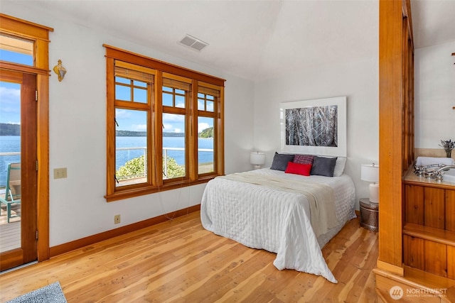 14010 SW Bates Rd, Vashon, WA 98070 - bedroom featuring light wood-type flooring, multiple windows, a water view, and baseboards