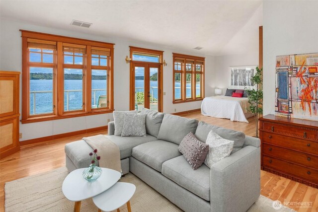 14010 SW Bates Rd, Vashon, WA 98070 - living room with light wood-style floors, a water view, french doors, and baseboards