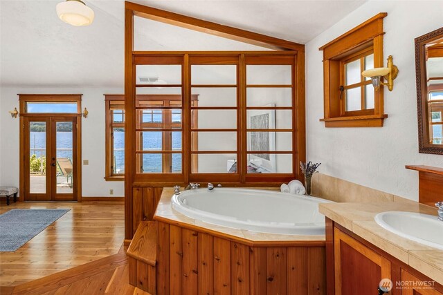 14010 SW Bates Rd, Vashon, WA 98070 - bathroom with wood finished floors, a garden tub, vanity, and baseboards