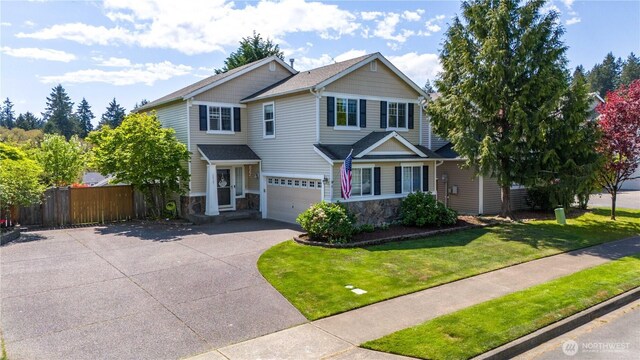 view of front of home with stone siding, driveway, and a garage