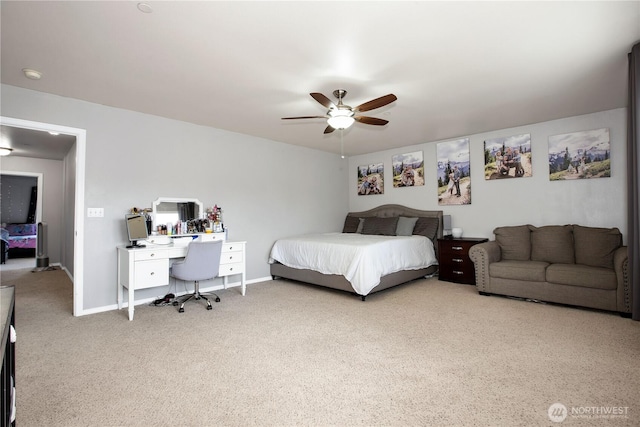 bedroom featuring carpet floors, an office area, a ceiling fan, and baseboards