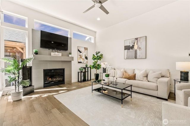 living room with wood finished floors, a ceiling fan, a fireplace, recessed lighting, and baseboards