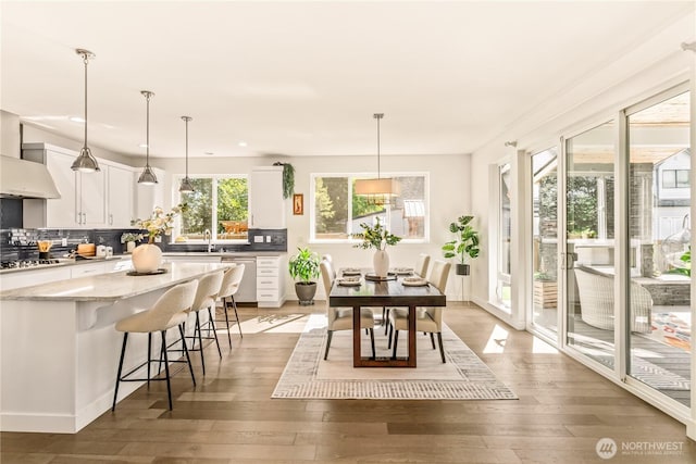 kitchen featuring white cabinetry, decorative backsplash, light wood finished floors, and recessed lighting