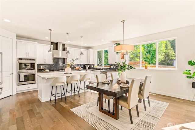 dining space featuring recessed lighting, light wood-style flooring, and baseboards