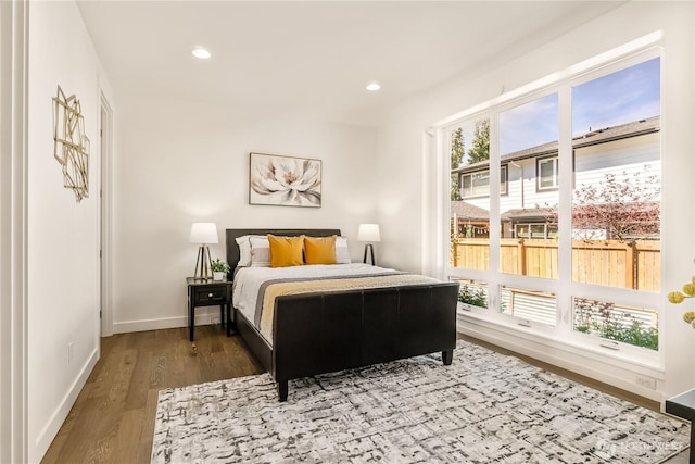 bedroom featuring baseboards, wood finished floors, and recessed lighting