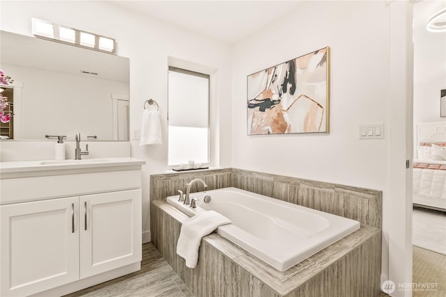 full bathroom with vanity, a garden tub, and connected bathroom