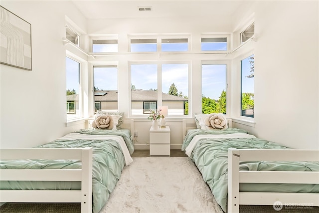 bedroom with multiple windows and wood finished floors