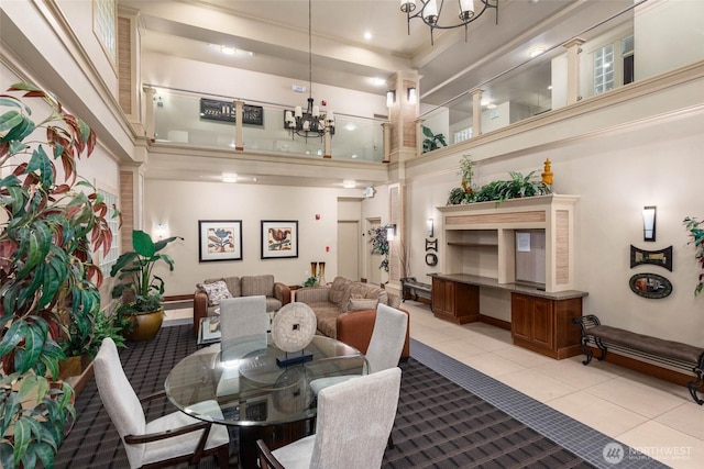 dining space featuring a chandelier, a high ceiling, light tile patterned flooring, and crown molding