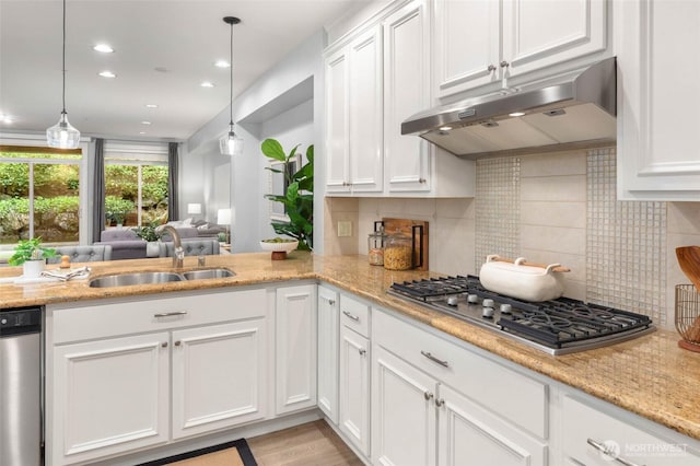 kitchen featuring under cabinet range hood, a sink, appliances with stainless steel finishes, white cabinetry, and recessed lighting