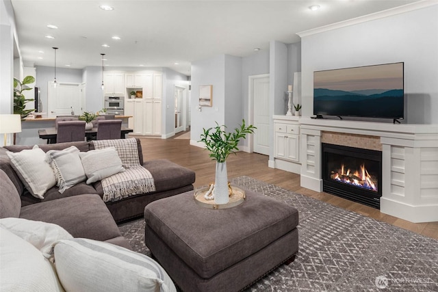 living room featuring a fireplace, wood finished floors, recessed lighting, and baseboards