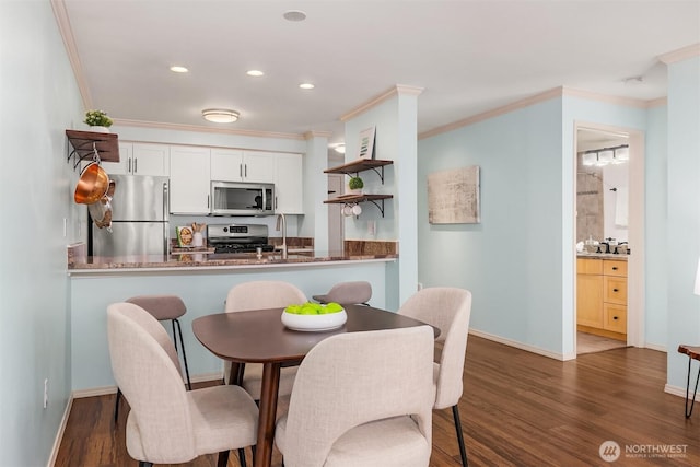 dining room with wood finished floors, ornamental molding, recessed lighting, and baseboards