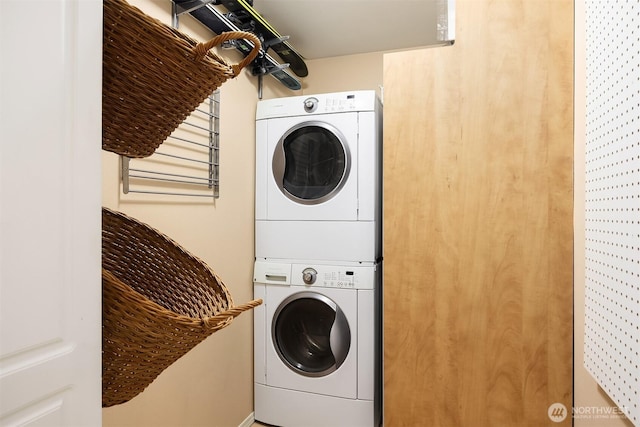 clothes washing area featuring stacked washer and clothes dryer