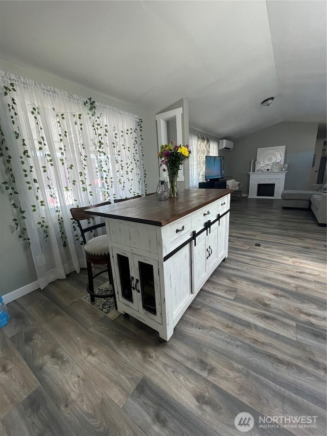 5600 Mt Solo Rd Unit 114, Longview, WA 98632 - kitchen featuring butcher block counters, lofted ceiling, dark wood-type flooring, a wall mounted air conditioner, and white cabinetry