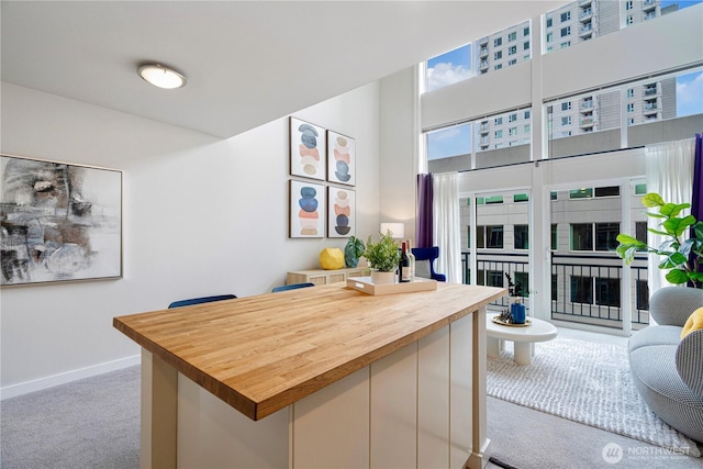 2415 2nd Ave Unit 743, Seattle, WA 98121 - dining space with carpet flooring, baseboards, a desk, and a high ceiling