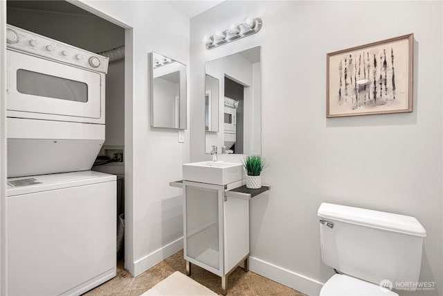 2415 2nd Ave Unit 743, Seattle, WA 98121 - bathroom with stacked washer / dryer, baseboards, toilet, and vanity