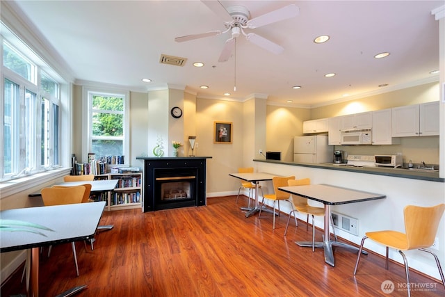 2415 2nd Ave Unit 743, Seattle, WA 98121 - kitchen with white appliances, dark countertops, a fireplace, wood finished floors, and recessed lighting
