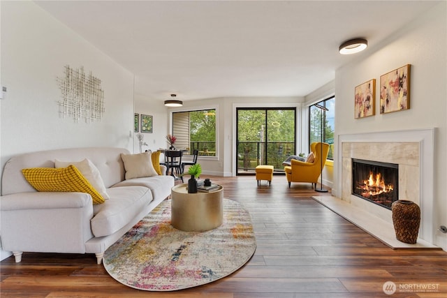 living area with a high end fireplace, wood finished floors, and baseboards