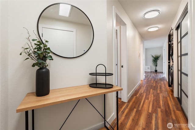 corridor with dark wood-style floors and baseboards