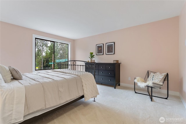 bedroom featuring light carpet and baseboards
