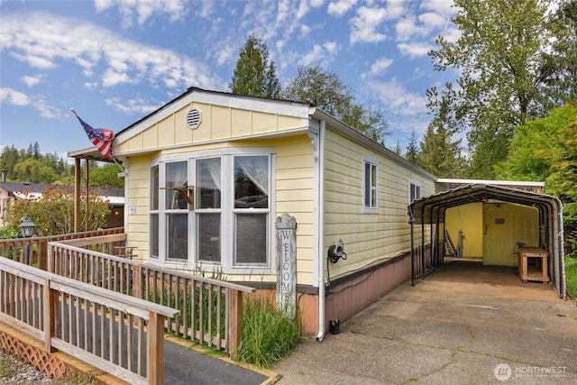 212 Old Owen Rd Unit 46, Sultan, WA 98294 - view of property exterior featuring a detached carport, board and batten siding, and driveway