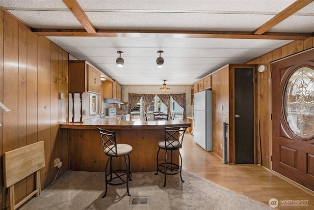 212 Old Owen Rd Unit 46, Sultan, WA 98294 - kitchen featuring white appliances, wooden walls, beam ceiling, a peninsula, and under cabinet range hood