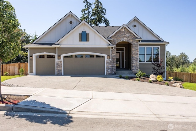 craftsman house featuring fence, stone siding, board and batten siding, and driveway