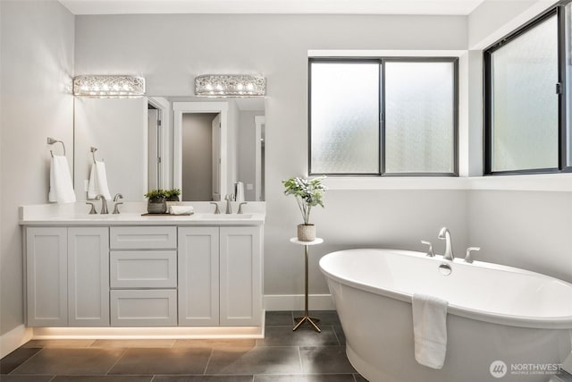 full bathroom with baseboards, a soaking tub, tile patterned floors, and double vanity